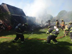 Firefighters Laying a Hose around a Structure Fire