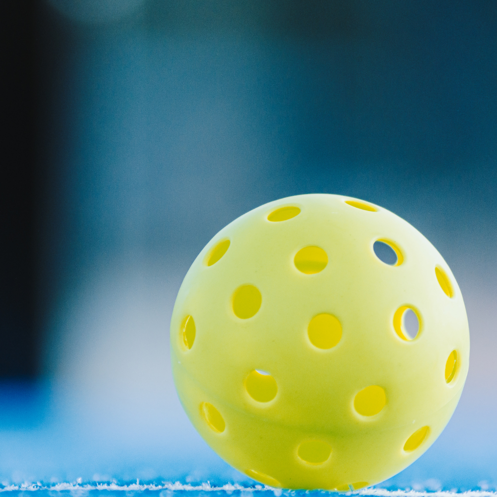 Pickleball Ball On Blue Court