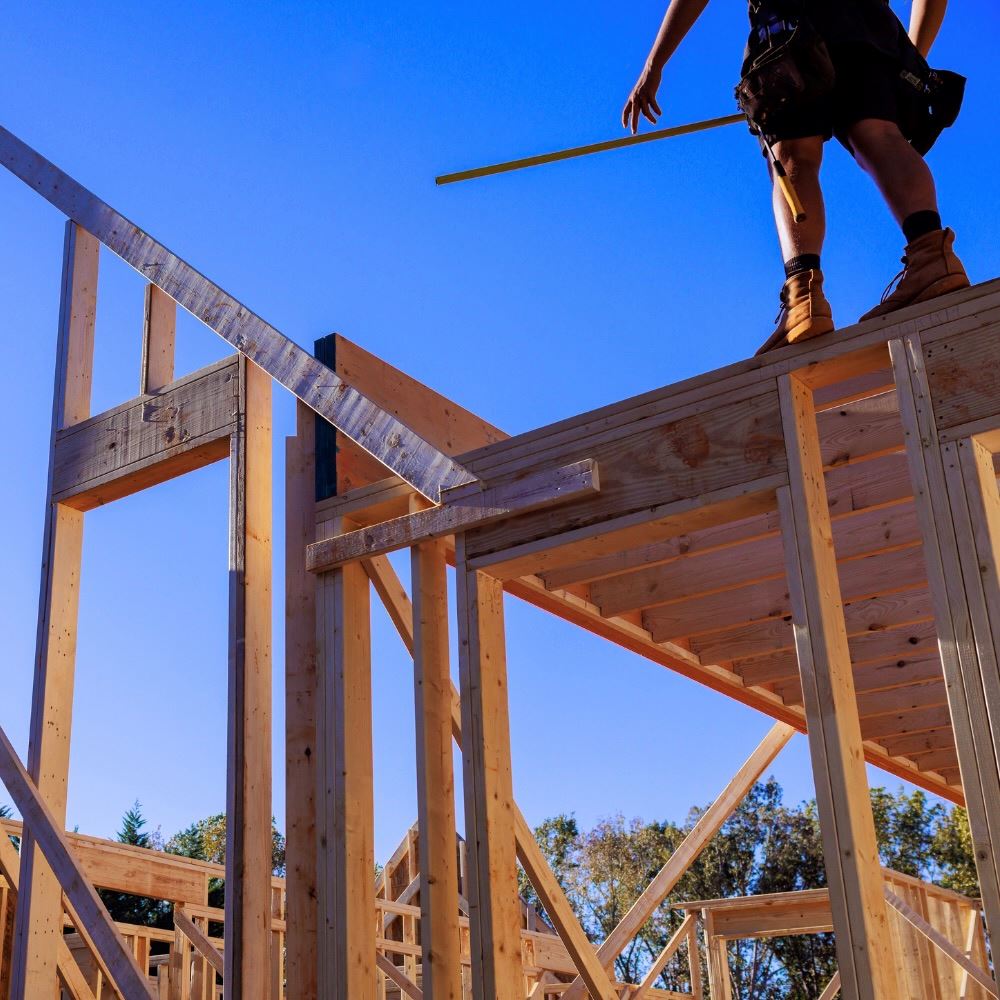 New Home Construction Photo With Worker Standing On Beam